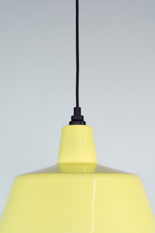 zwarte trekontlaster op geel emaille hanglamp