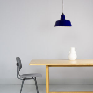 blauw emaille lamp van EBLI boven een HAY tafel