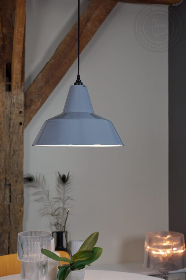 close-up van een grijs emaille lamp boven ronde witte vintage tafel