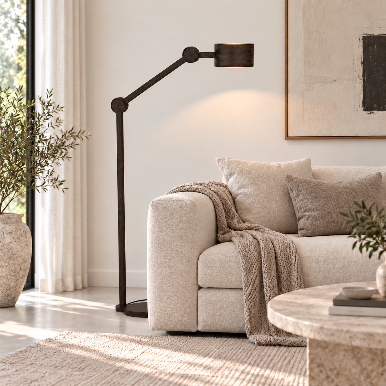 Arend Groosman Circle Arc hoge vloerlamp in zwart hout naast een lichte bank in een modern interieur.